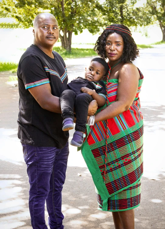 a man and a woman standing with a baby