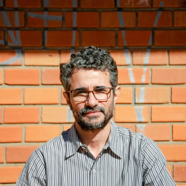 the man is posing for the camera while wearing glasses