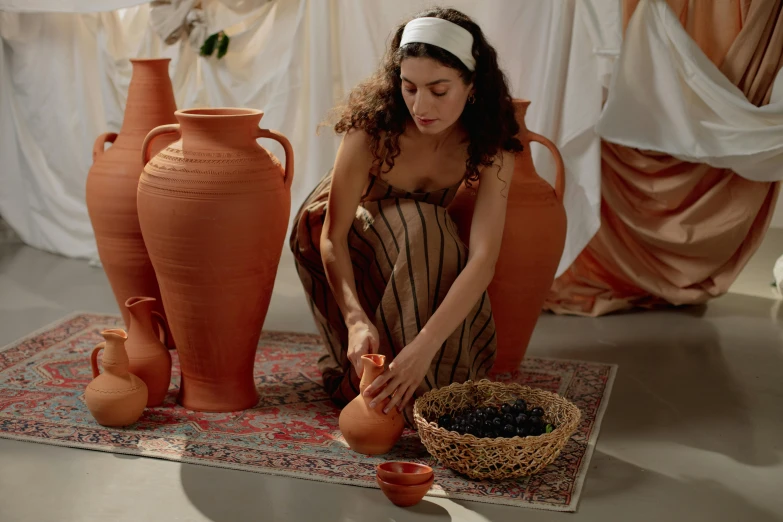 a woman in a room working on a vase