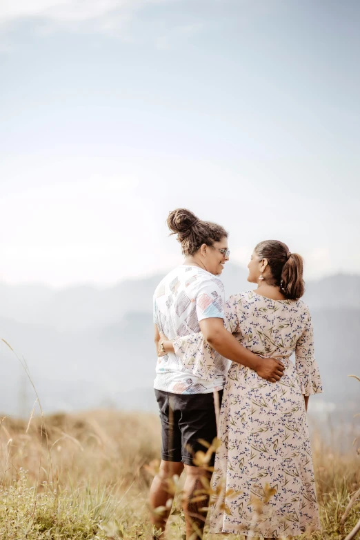 two people standing in tall grass looking at each other