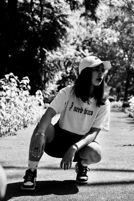 a person in black shorts and white shirt kneeling on grass