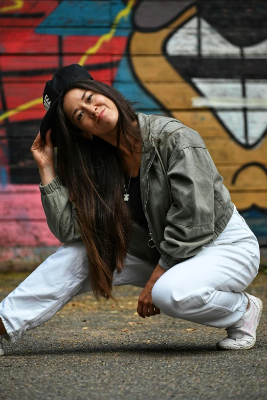 a woman squats down, her long hair up against her chest