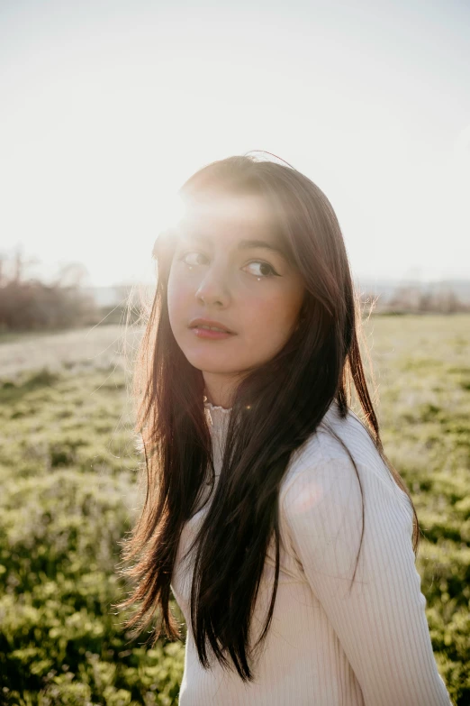 a woman standing on a field looking into the distance