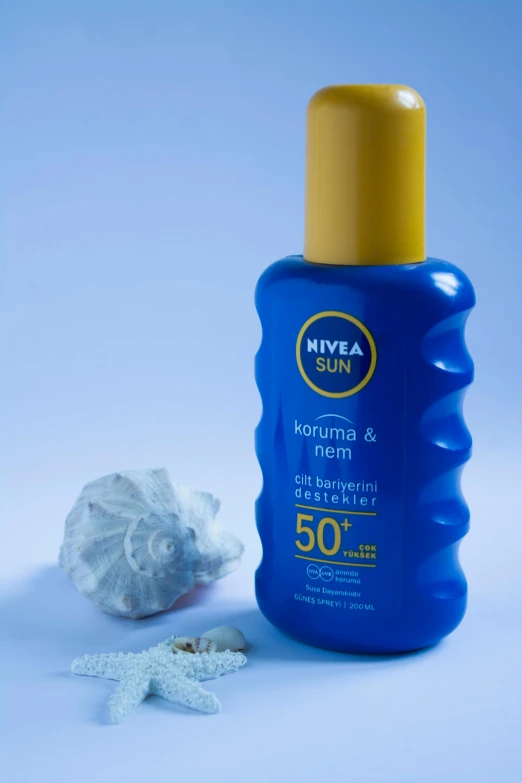 a bottle of suns cream next to a starfish on a blue surface