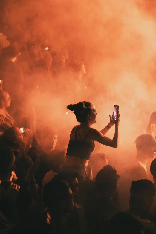 woman on her cell phone in the middle of an illuminated crowd