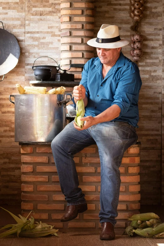 a man is sitting on a brick wall next to some plants