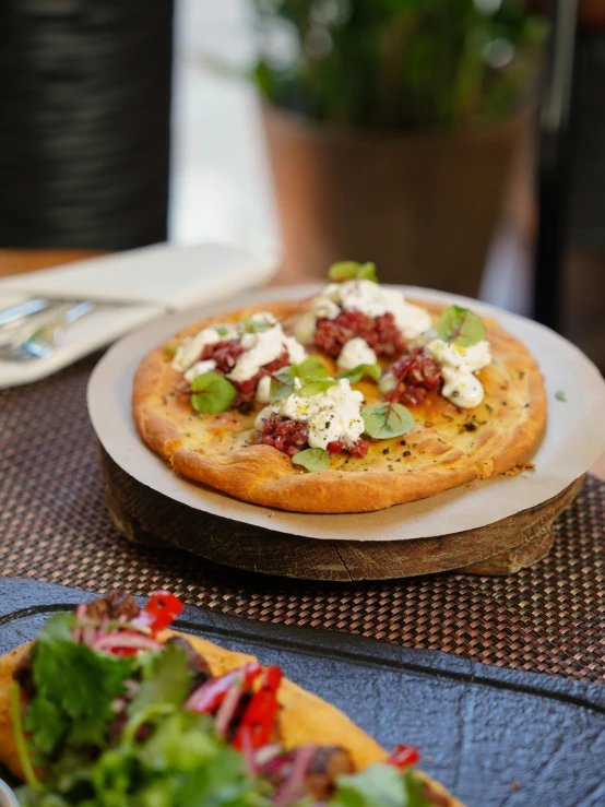 a small pizza with green and red ingredients