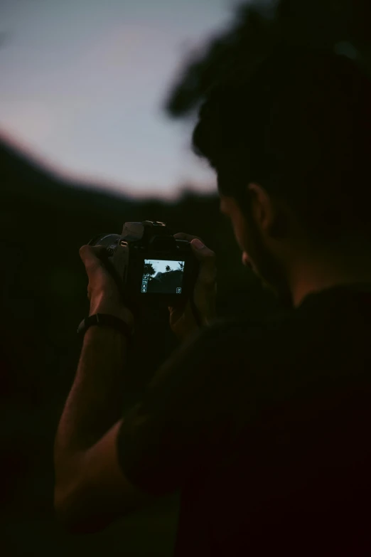 a man taking a po of a sunset with his camera