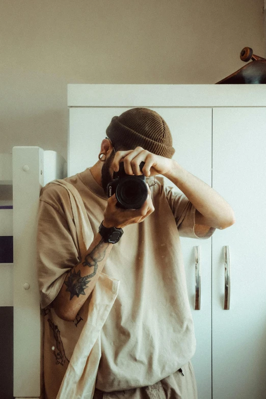 man taking selfie while standing in front of white cupboards