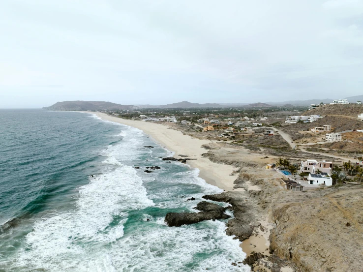 an aerial view of a beach, water and town