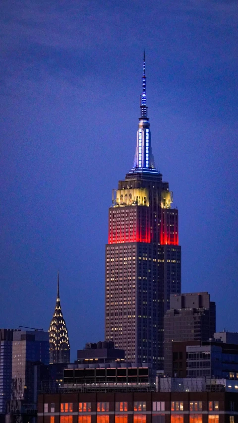 a building is lit up with red, white and blue lights