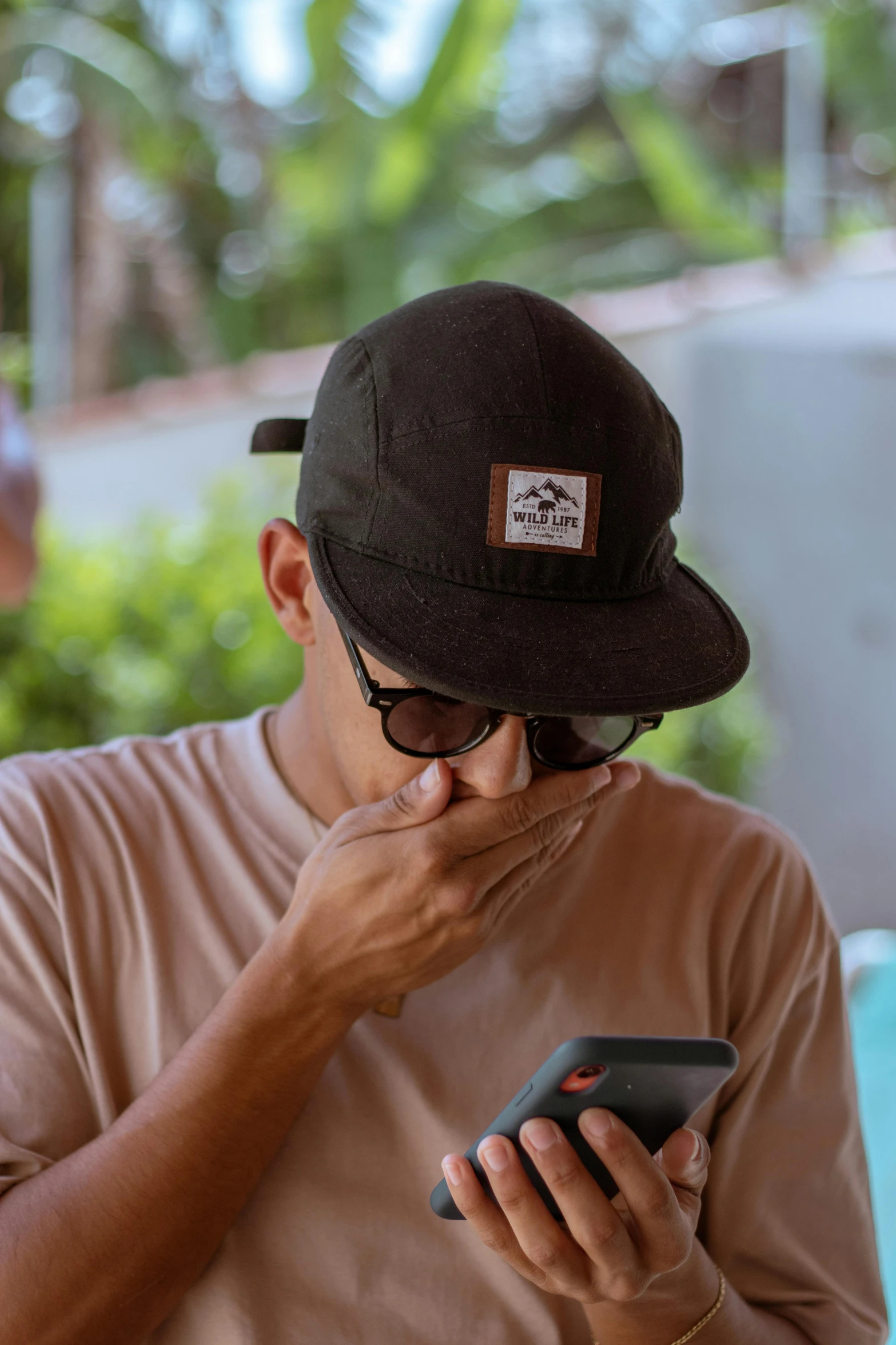 a man wearing a hat using his cell phone