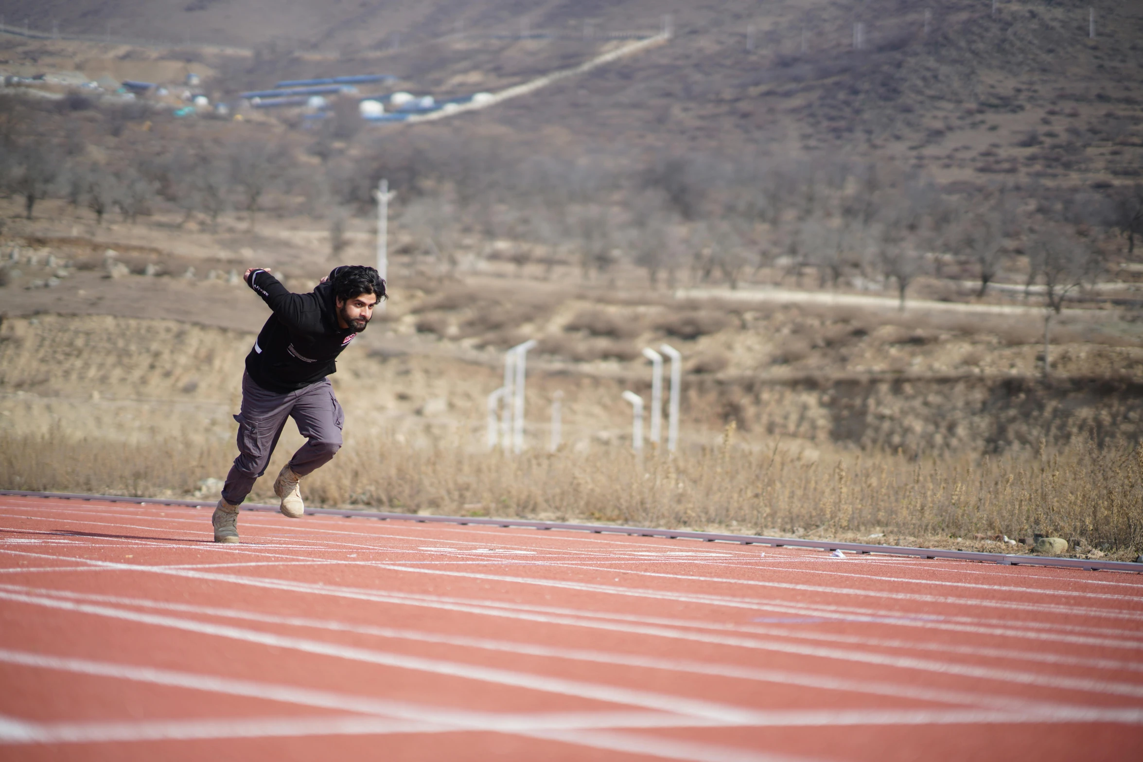 a man is running on the track with a helmet