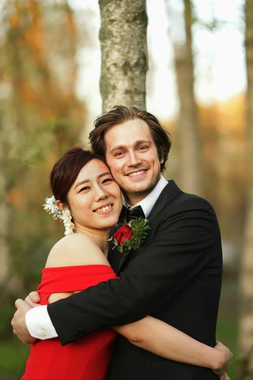 a man hugs a woman in a red dress