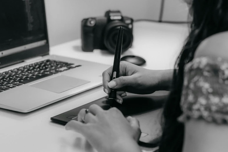 a person doing soing on the desk in front of the laptop