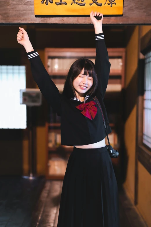 a woman in a long black skirt holding up a sign