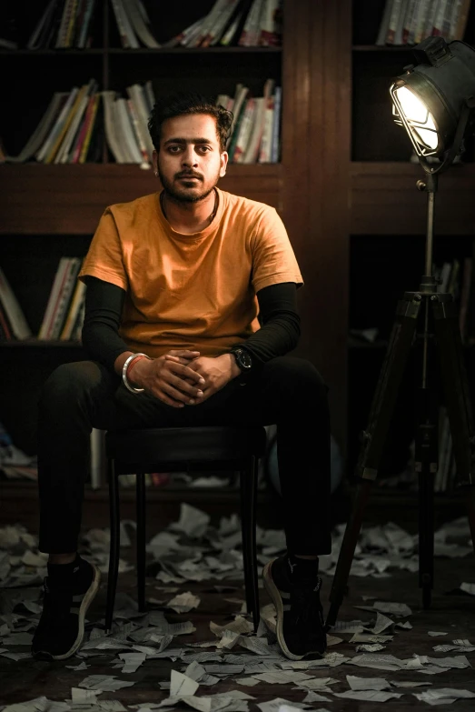 a man sitting in a chair in front of a camera on a tripod