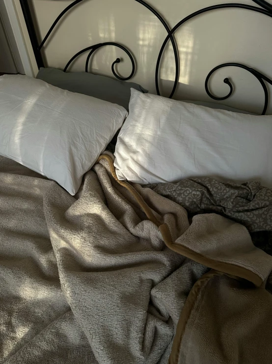 a bed with a metal headboard with a white blanket