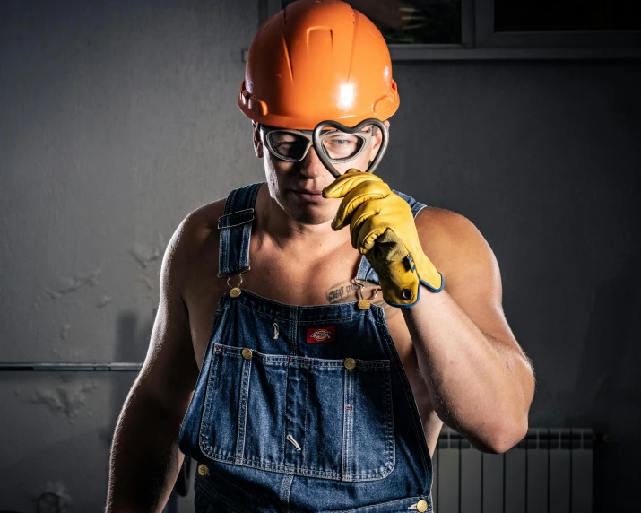 a man wearing a blue overalls holding a banana