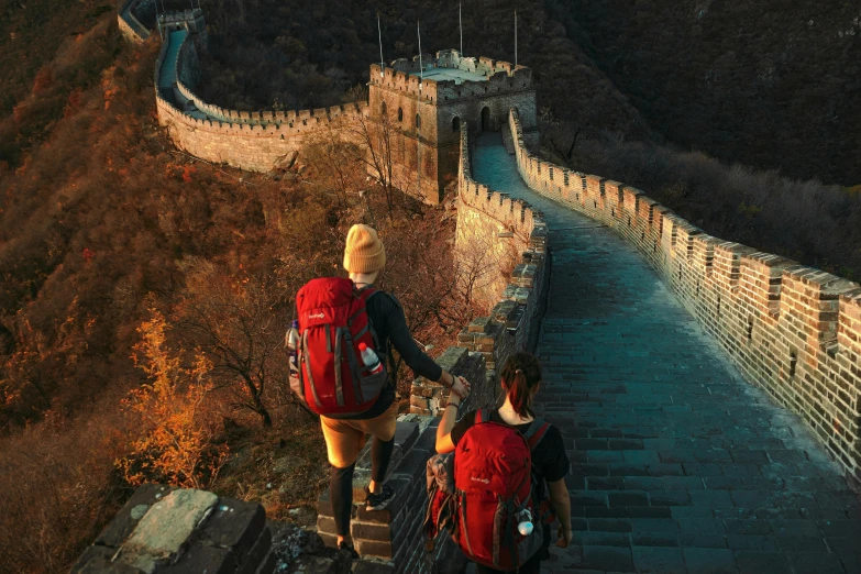 two people with their backpacks walking up the stairs