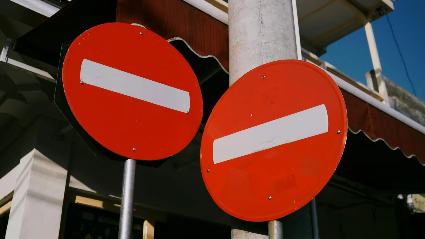 a couple of red and white signs sitting next to a building