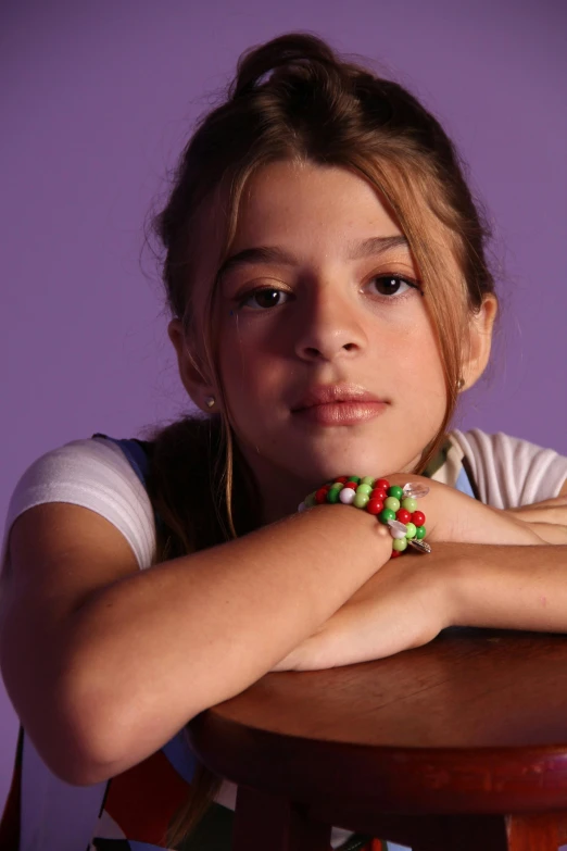 a pretty  with her arms folded on top of a table