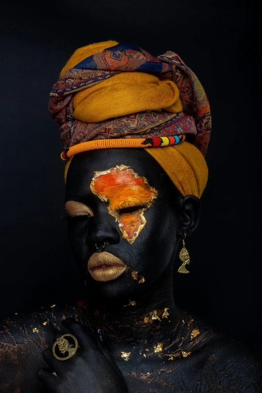 a painted woman's face with yellow, gold and black powder