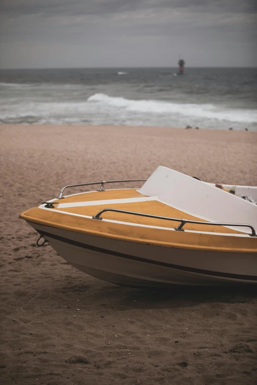 a small wooden boat sitting on a beach near the ocean