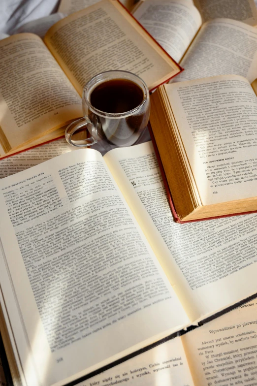 the open book is next to an opened coffee mug