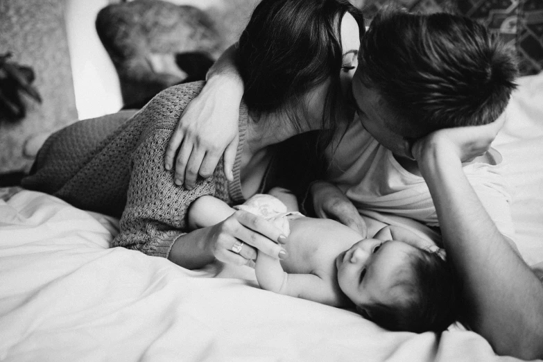 a woman in white shirt laying down with baby