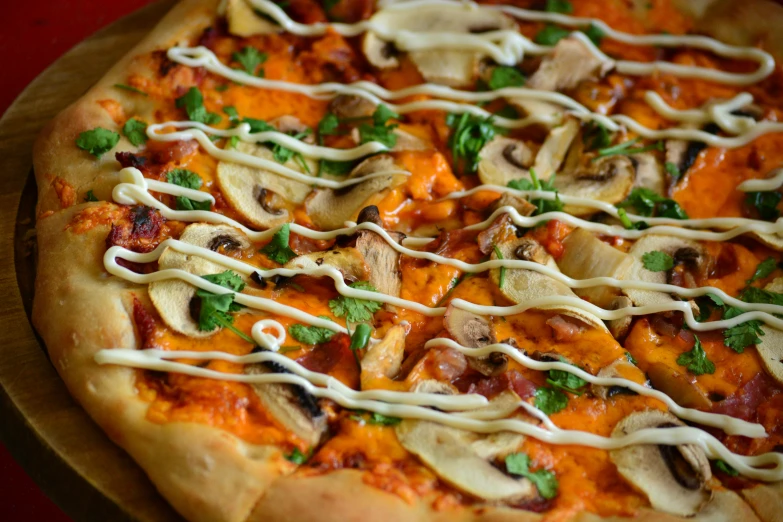 a pizza on a wooden tray topped with cheese and toppings