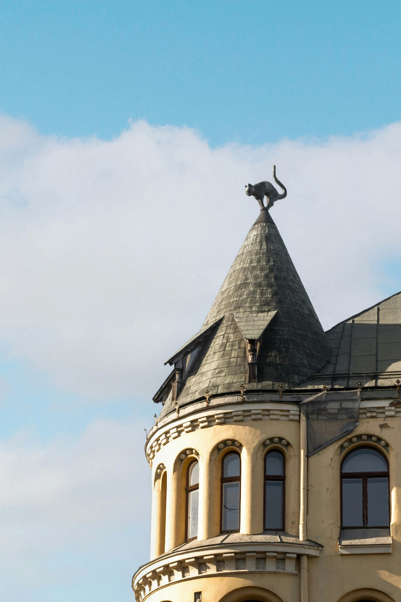 there is a tall building with a clock tower and a statue on top