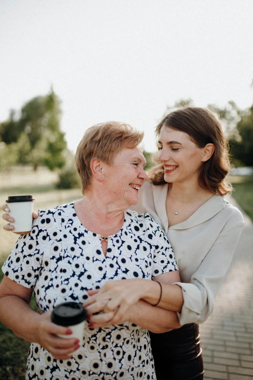 an older woman hugs a younger woman on the cheek