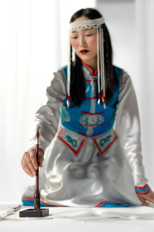 woman wearing traditional chinese dress, playing with stick