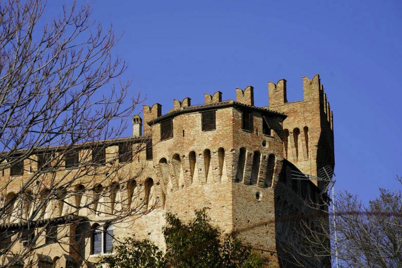 a large, old brick castle tower in front of a blue sky