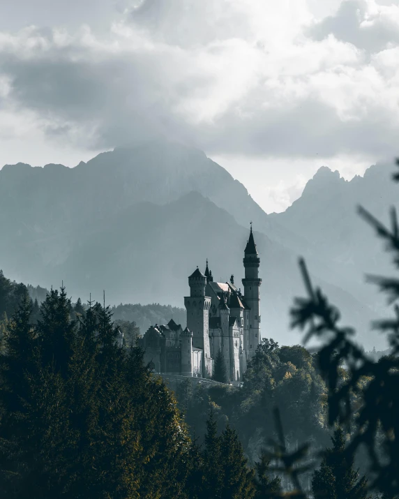 an old castle atop the mountain with mountains in the background