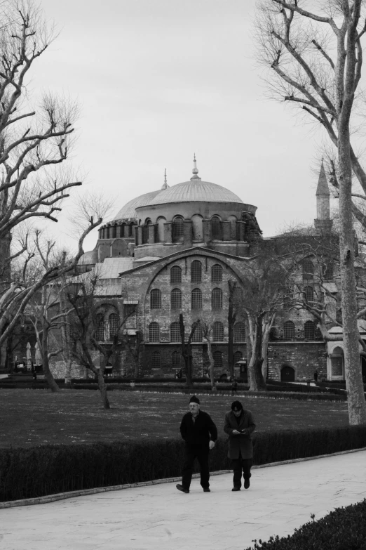 two people standing in front of a large building