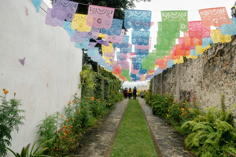 a line of colored flags hanging from a stone walkway