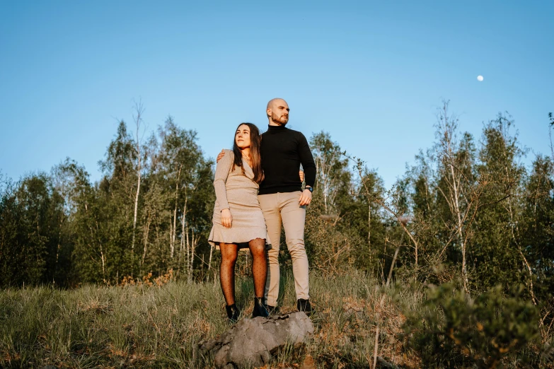 the young couple are walking through the forest