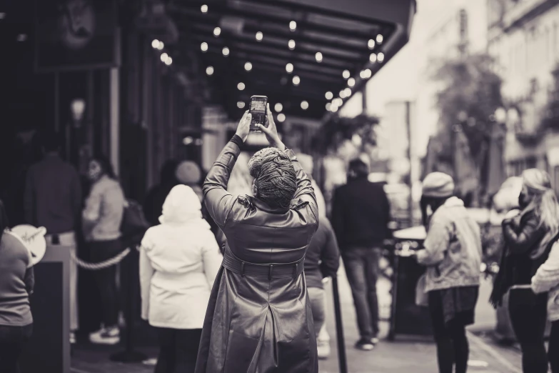 a woman is taking pictures on the sidewalk