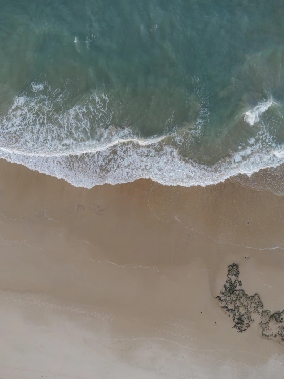 the ocean waves come in to shore at a beach