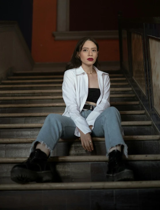 the young woman is posing for a po in jeans and a white shirt