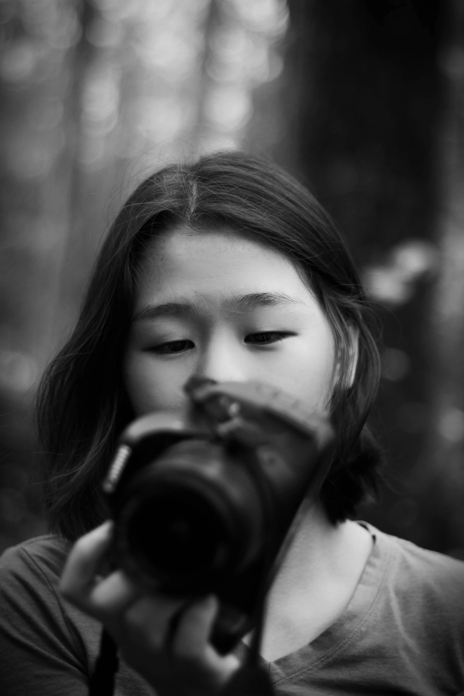 a woman standing in front of a forest holding a camera