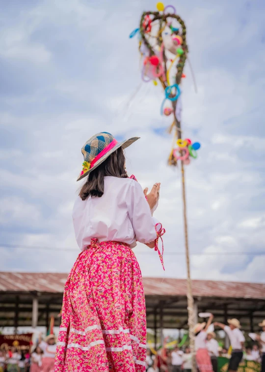 the woman in the colorful skirt is standing outside