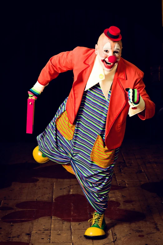 a clown in colorful costume on brick paved street