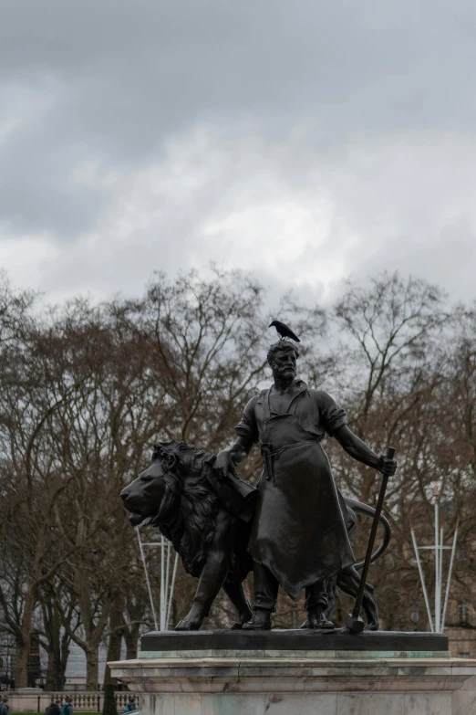 a bronze statue of a man holding a cane and holding two dogs