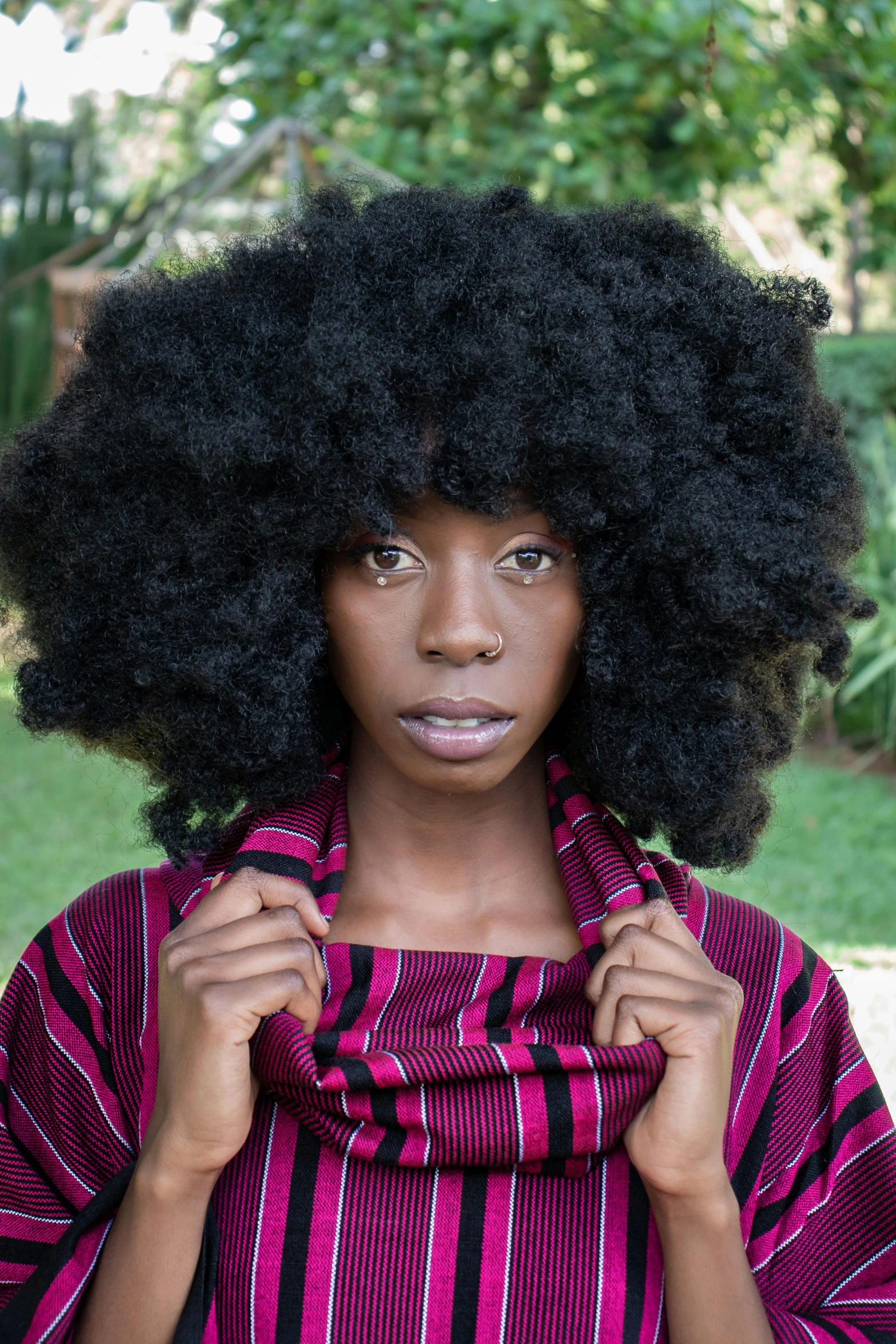 a woman with long curly hair is looking into the camera