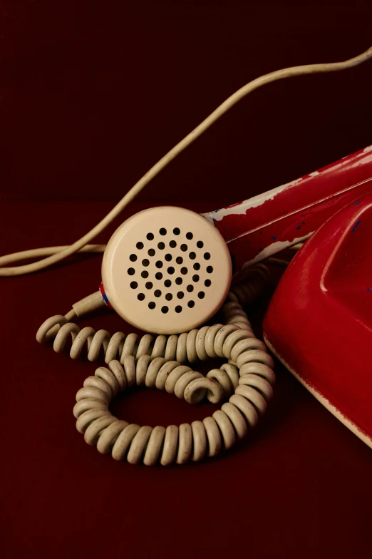 a telephone that is red in color and a cord