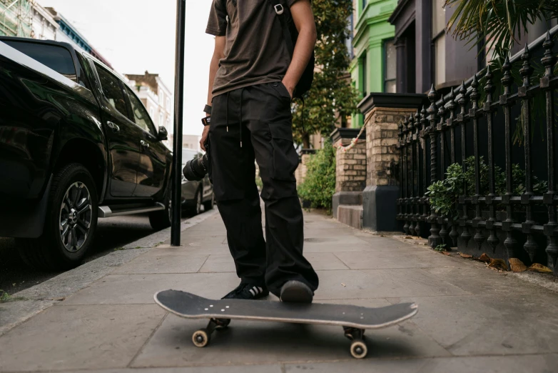 a person is skateboarding on the sidewalk near the car