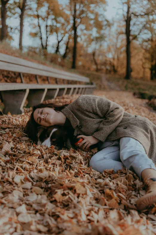 an adult lies on the ground while holding a baby dog